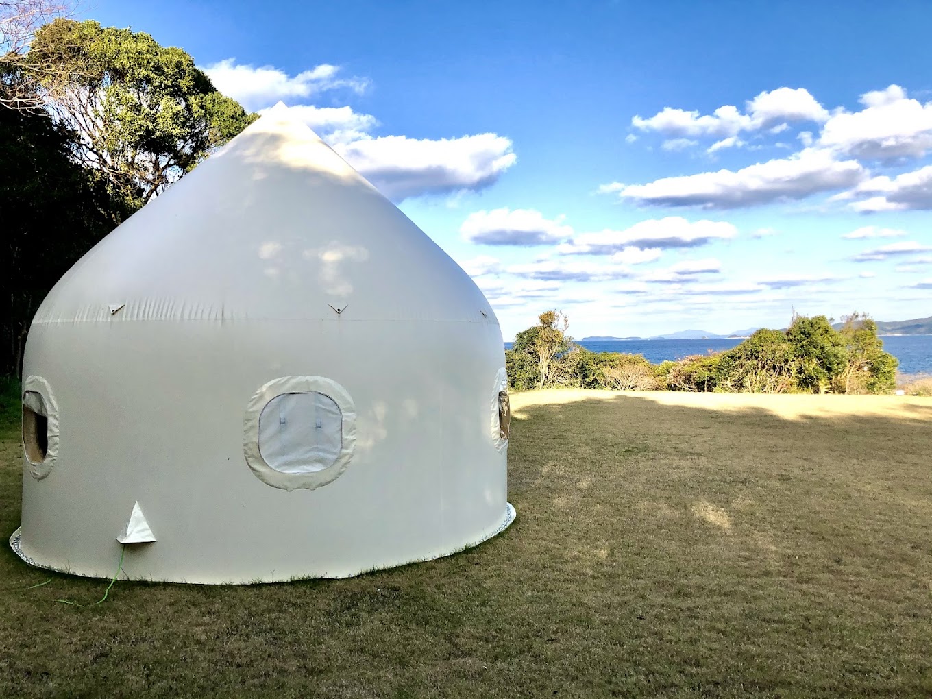 Actual yurt at Karadomari Village with sea visible beyond the lawn