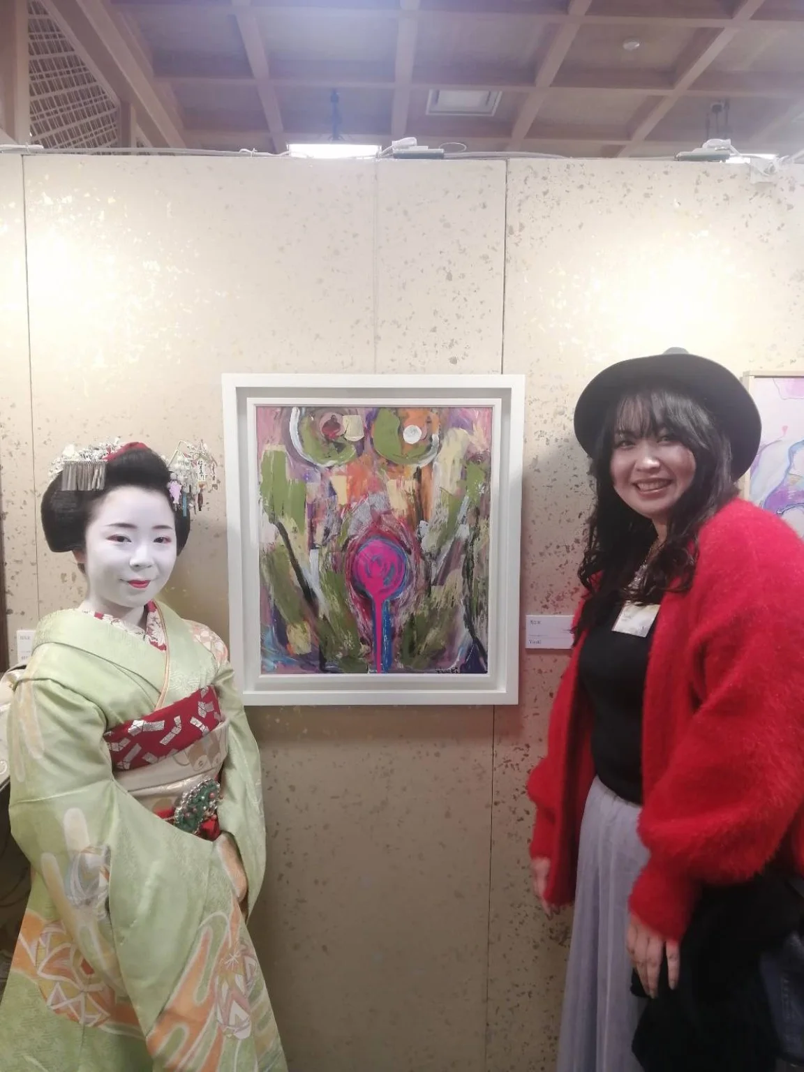 Yuuki beside an exhibited artwork