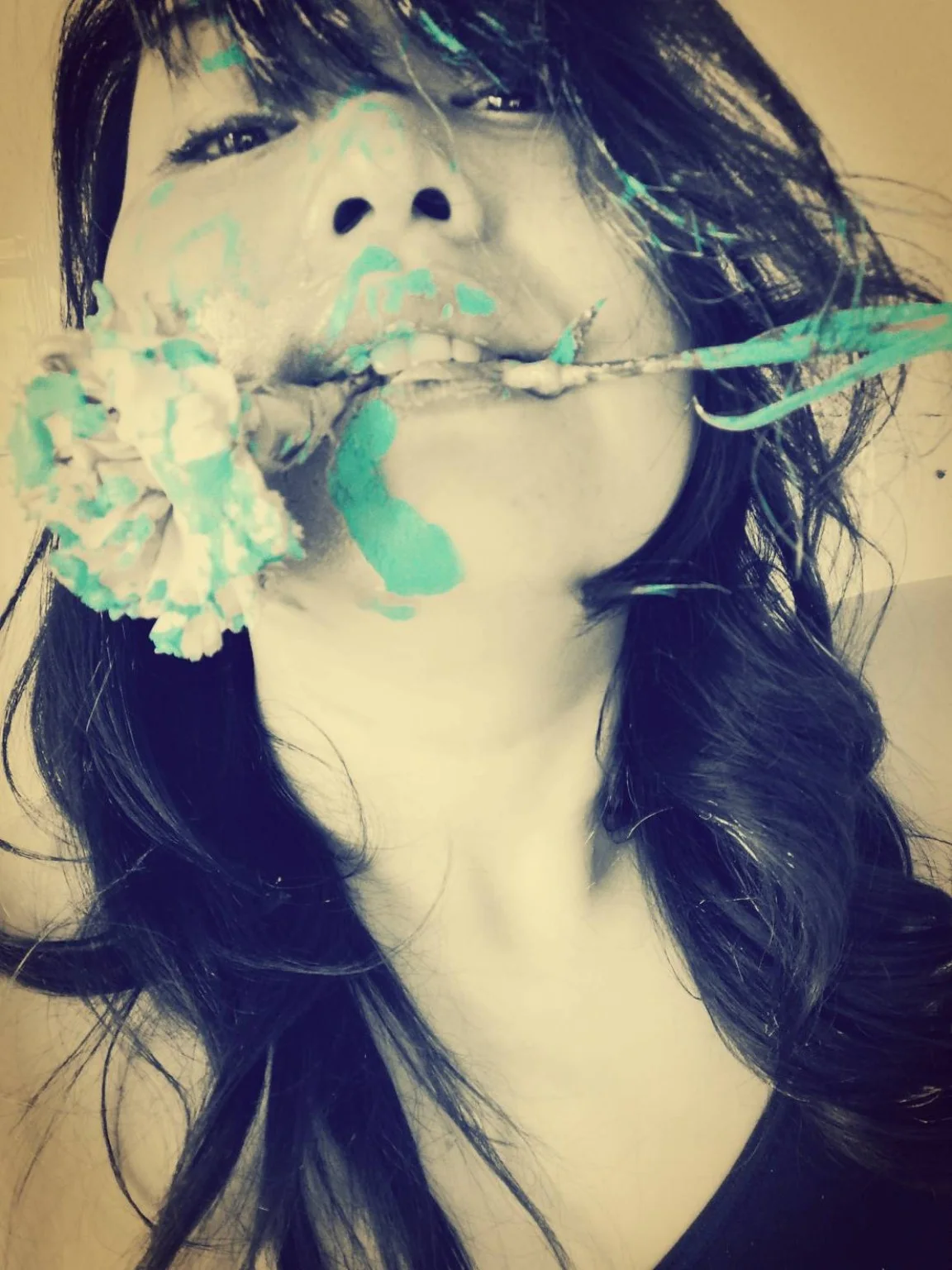Yuuki holding a flower marked with turquoise paint